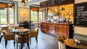 A cozy cafe with wooden furniture, a bar area, and a chalkboard menu listing coffee, latte, cappuccino, and hot chocolate. - The Hand Hotel Llangollen by Compass Hospitality (Llangollen)