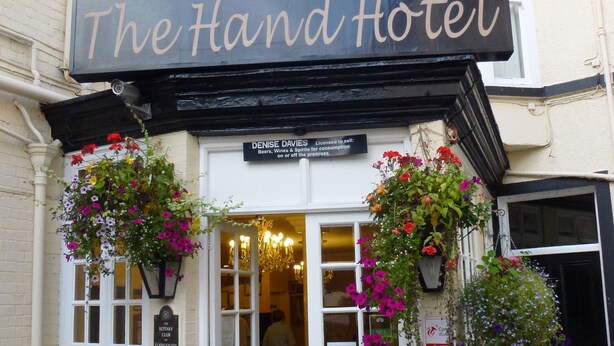 L’hôtel « The Hand », reconnaissable à son auvent noir, sa porte blanche et ses jardinières fleuries.