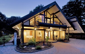 Een modern huis met een ruim balkon, een goed verlichte entree en een verharde oprit.