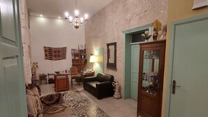 A living room with a patterned rug, a sofa, a coffee table, a lamp, and a cabinet. - Al Bishara Guest house (Nazareth)