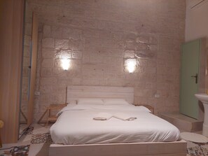 A bedroom with a wooden bed, white bedding, a green door, and a tiled floor. - Al Bishara Guest house (Nazareth)
