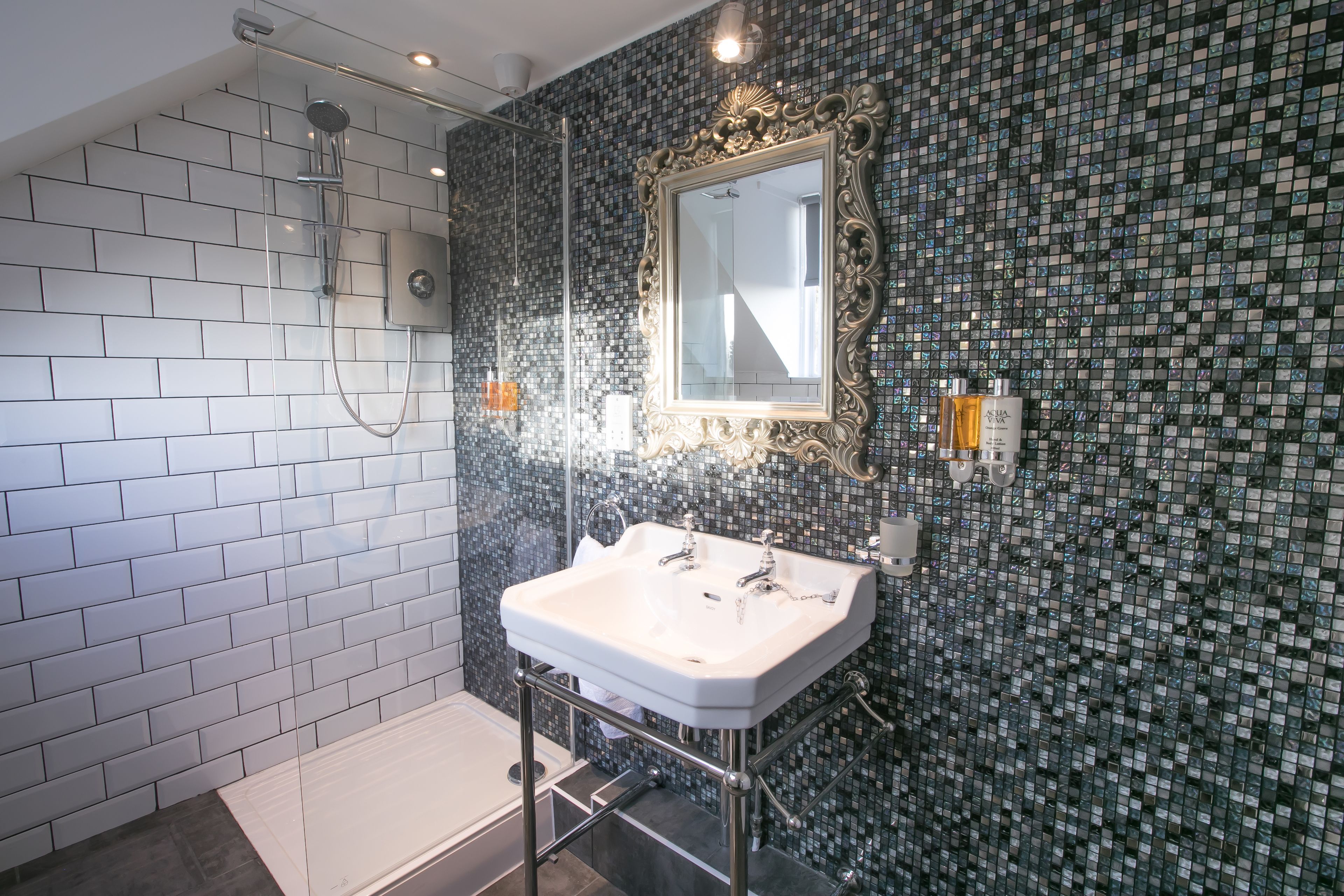 A bathroom with a white sink, a mirror, and a shower.