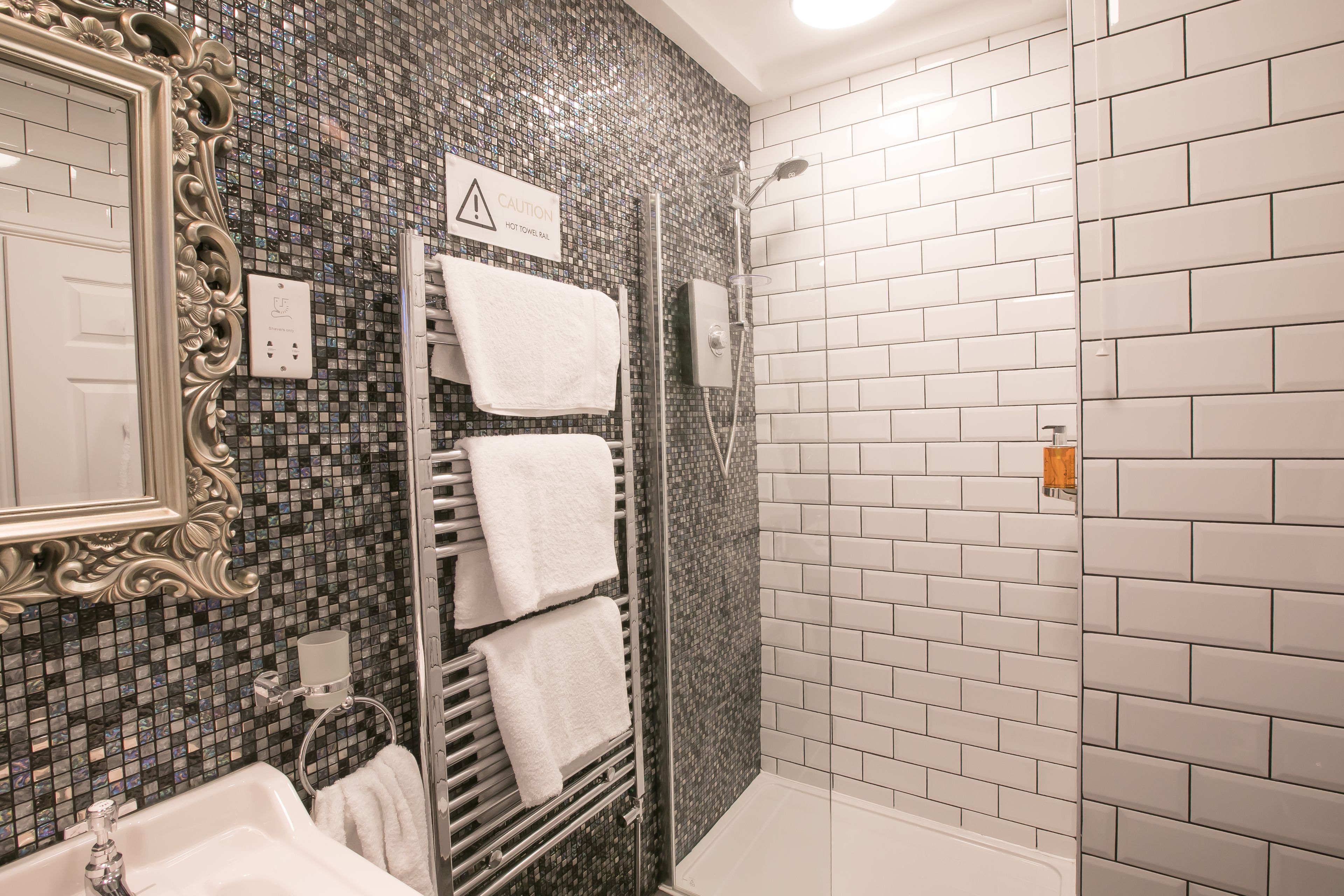 Un bagno con doccia, lavandino e specchio.