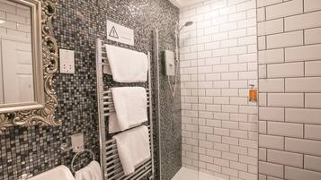 Un bagno con doccia, lavandino e specchio.