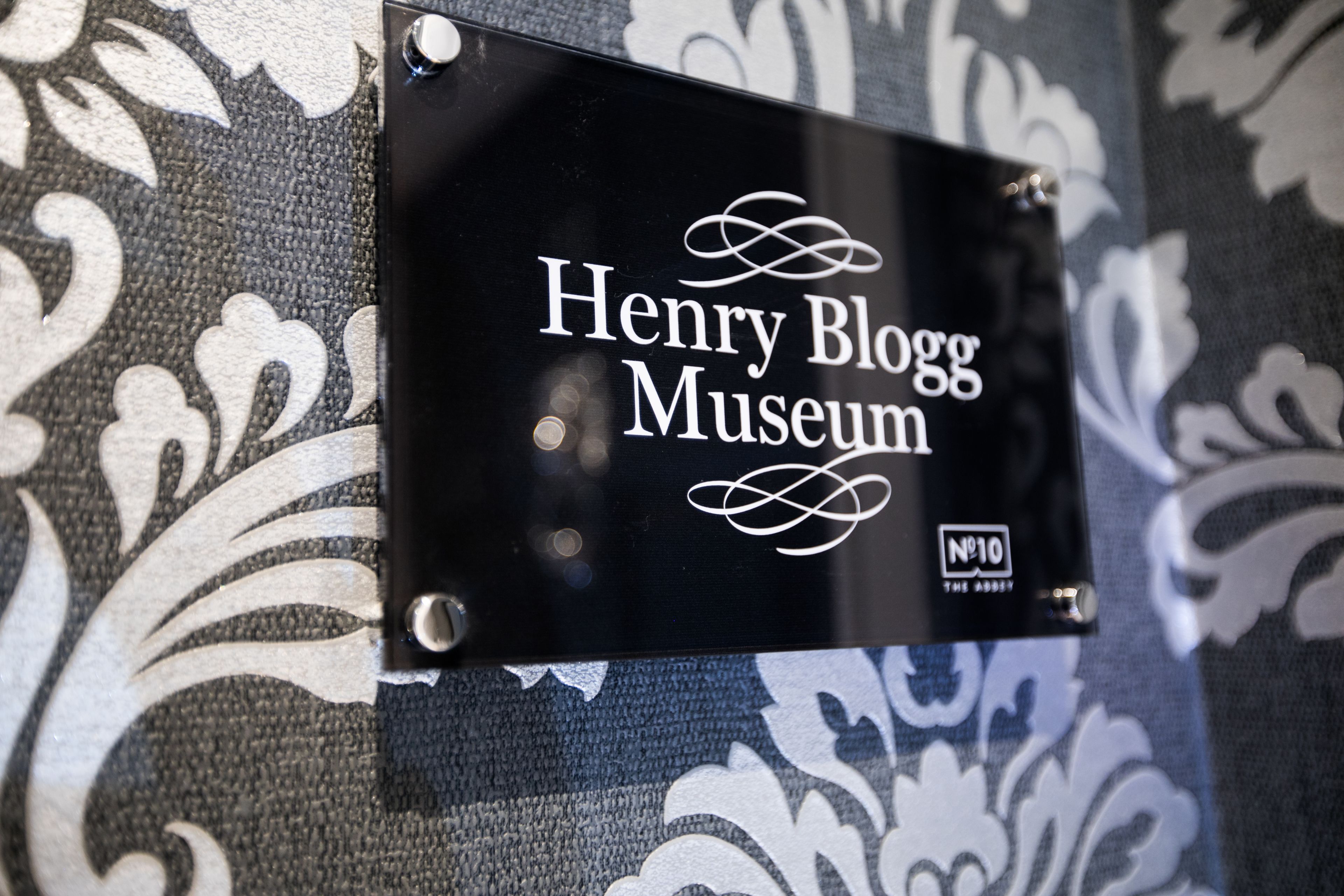A sign for the Henry Boggs Museum with a decorative background.