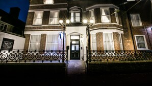 A Victorian-style building with a prominent entrance, a sign reading "No 10 The Abbey," and a black wrought iron fence in front. - Number 10 The Abbey (Wymondham)