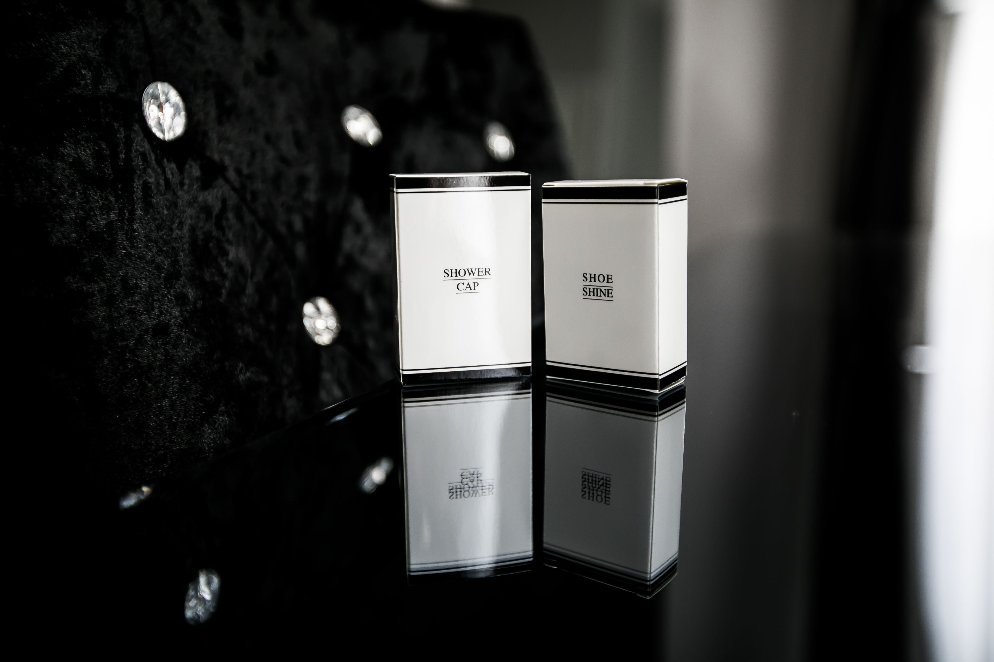 Dos cajas blancas con texto, colocadas sobre una superficie reflectante.