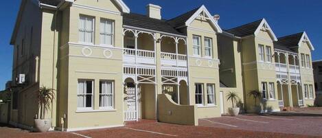 A large, two-story building with a symmetrical facade, multiple windows, and a central entrance with a decorative archway.