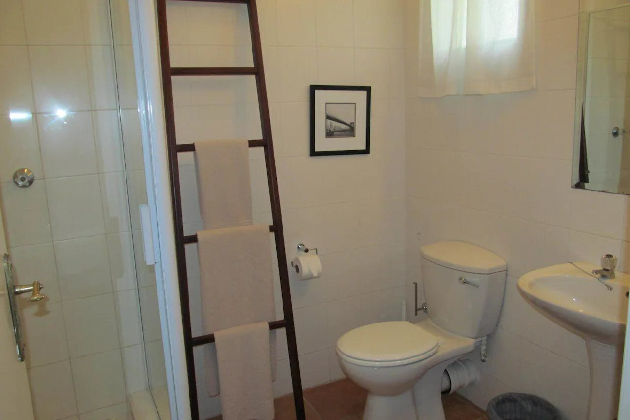 Un baño con inodoro, lavamanos y un cuadro en la pared.