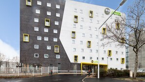 A modern hotel with a unique architectural design, featuring a mix of dark and light facades, and a prominent B&B logo. - B&B HOTEL NANTERRE Rueil Malmaison (Nanterre)