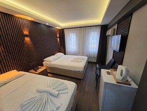 Habitación triple Deluxe | Minibar, caja fuerte, escritorio y tabla de planchar con plancha