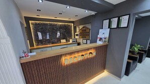A reception desk with a wooden finish and illuminated letters spelling 'RECEPTION'. - Gizem Pansiyon (Çanakkale)