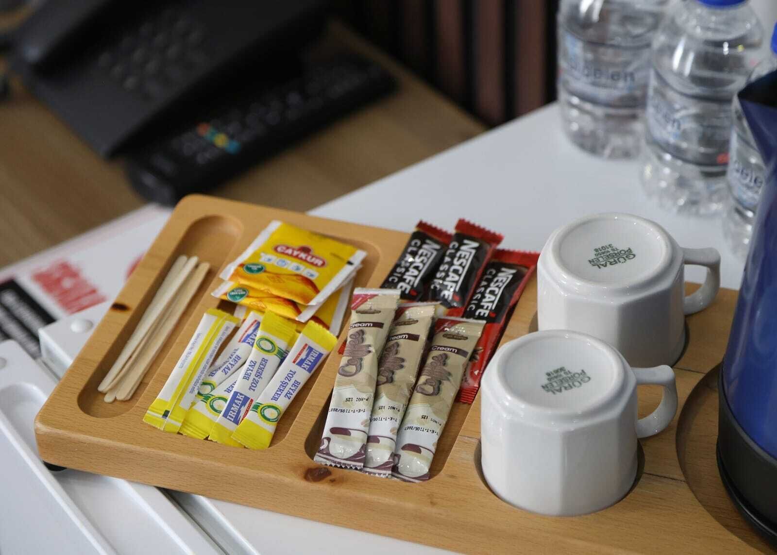 Uma bandeja com alimentos e duas xícaras de café brancas sobre uma mesa.