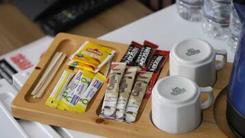 Uma bandeja com alimentos e duas xícaras de café brancas sobre uma mesa.