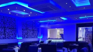A restaurant with tables and chairs, blue lighting, and a modern interior design. - The Charles Hotel (Chatham)