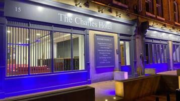 The Charles Hotel with a sign indicating rooms from level E, including single/double rooms, suites, and a restaurant.
