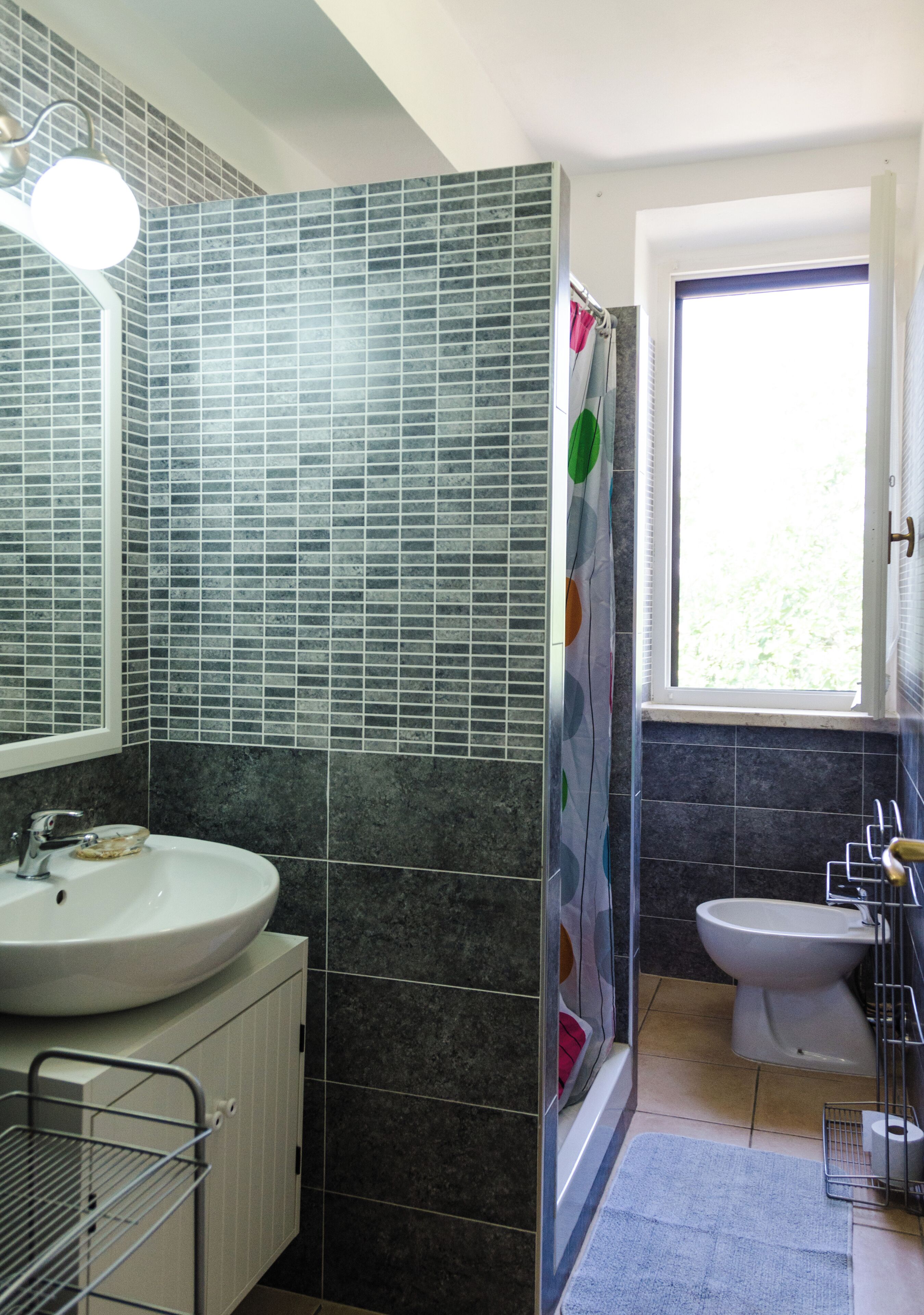 A bathroom with a sink, toilet, and shower area.