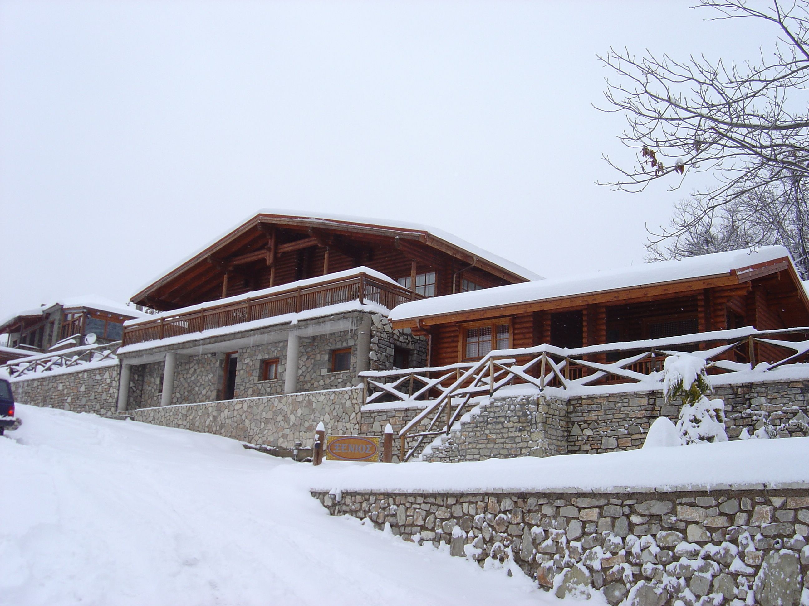 A stone building with wooden balconies and a snow-covered roof.
