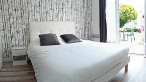 Un dormitorio con una cama grande, una silla y un escritorio.