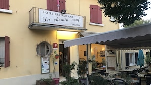 Ein Hotelrestaurant mit Außenbereich, Blumentöpfen und einem Schild mit der Aufschrift 'HOTEL RESTAURANT Du chemin neuf'.