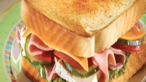 Un sándwich con varias capas de ingredientes sobre un plato.