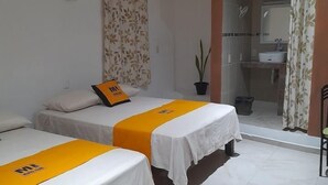 Habitación de hotel con dos camas, un baño y aire acondicionado.