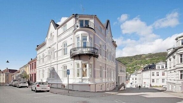 A multi-story building with a classical architectural style, featuring a prominent balcony and large windows. - Modern Apartment In The City Center (Bergen)
