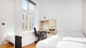 A bedroom with a bed, a desk, a chair, and a wardrobe. - Modern Apartment In The City Center (Bergen)