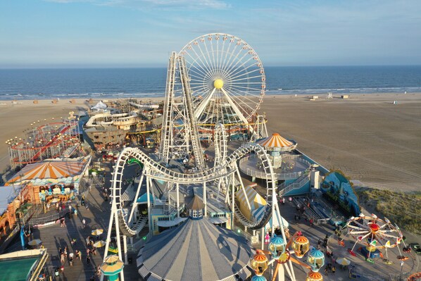 A large Ferris wheel and roller coaster at a seaside amusement park. - Beach Colony Motel (Wildwood Crest)