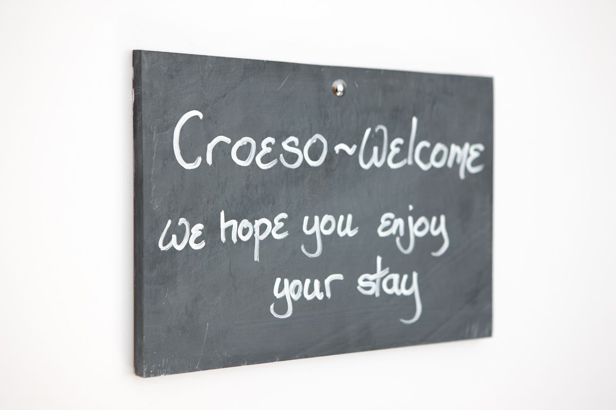 A blackboard with the text "Croeso Welcome We hope you enjoy your stay" written in white chalk.