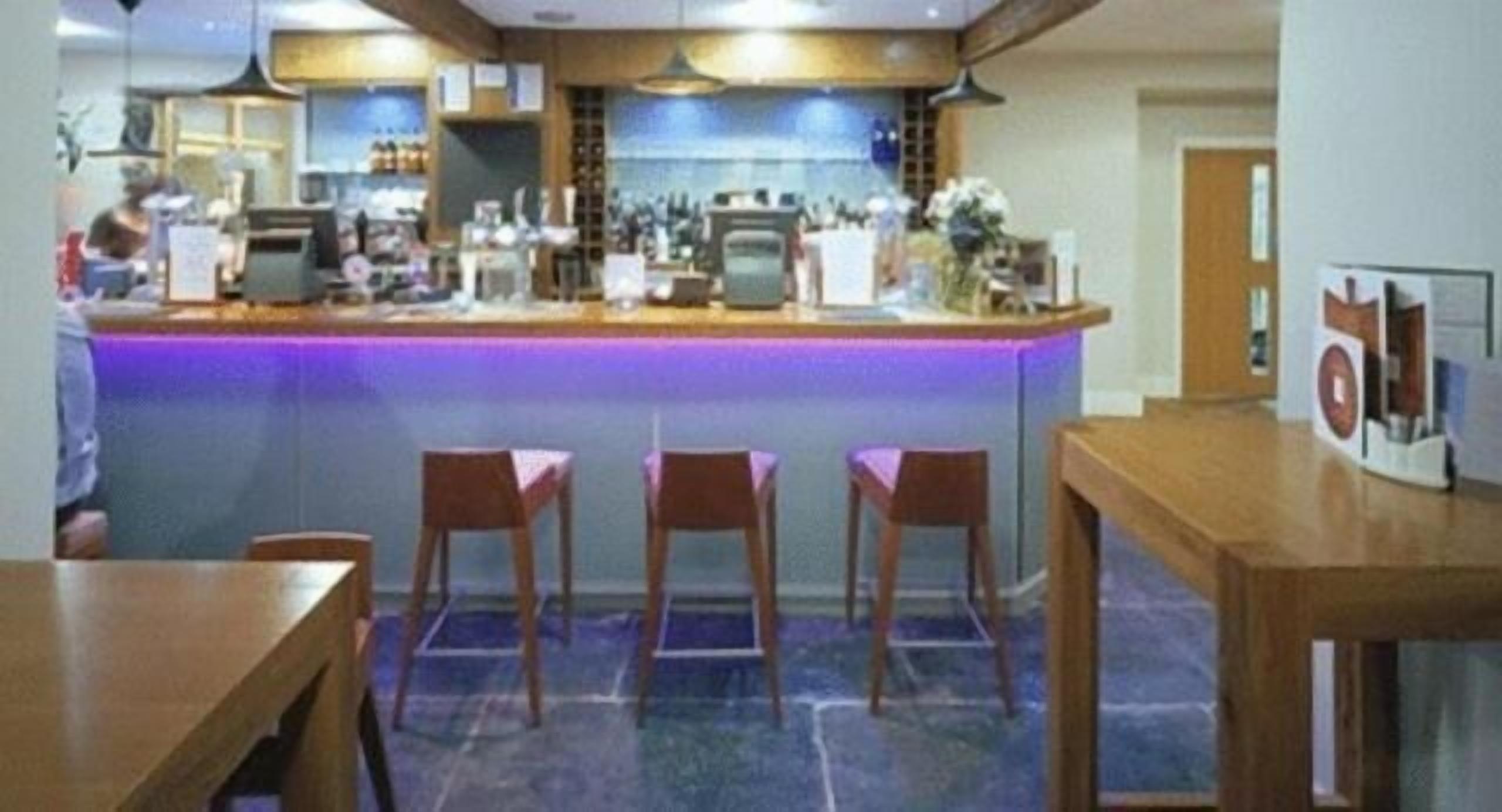 A bar area with a counter, stools, and a tiled floor.