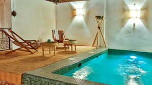 A swimming pool with a tiled edge, wooden deck, and two lounge chairs. - Dar Dada Mouss (Marrakech)