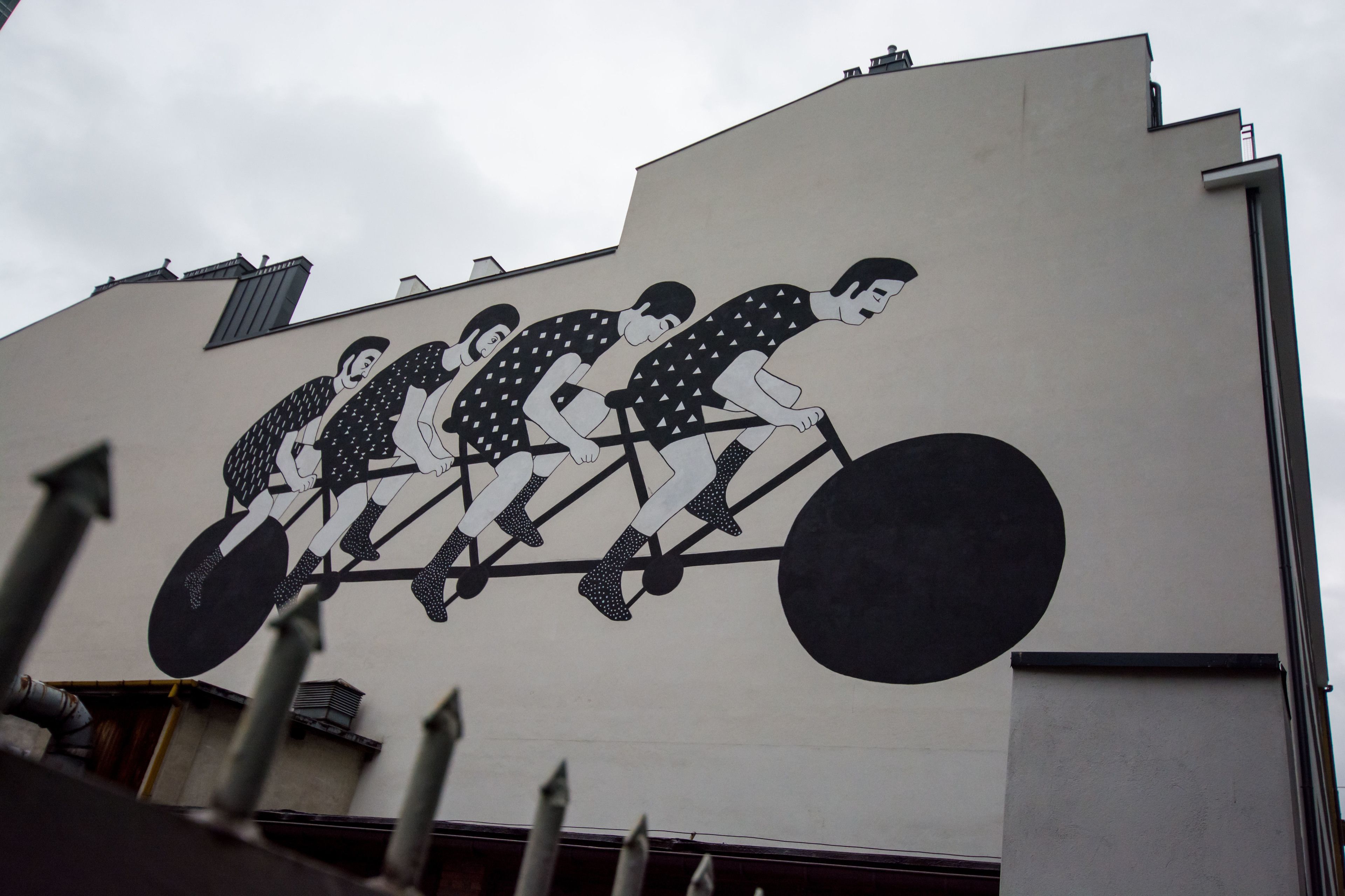 A mural of four cyclists on a track.