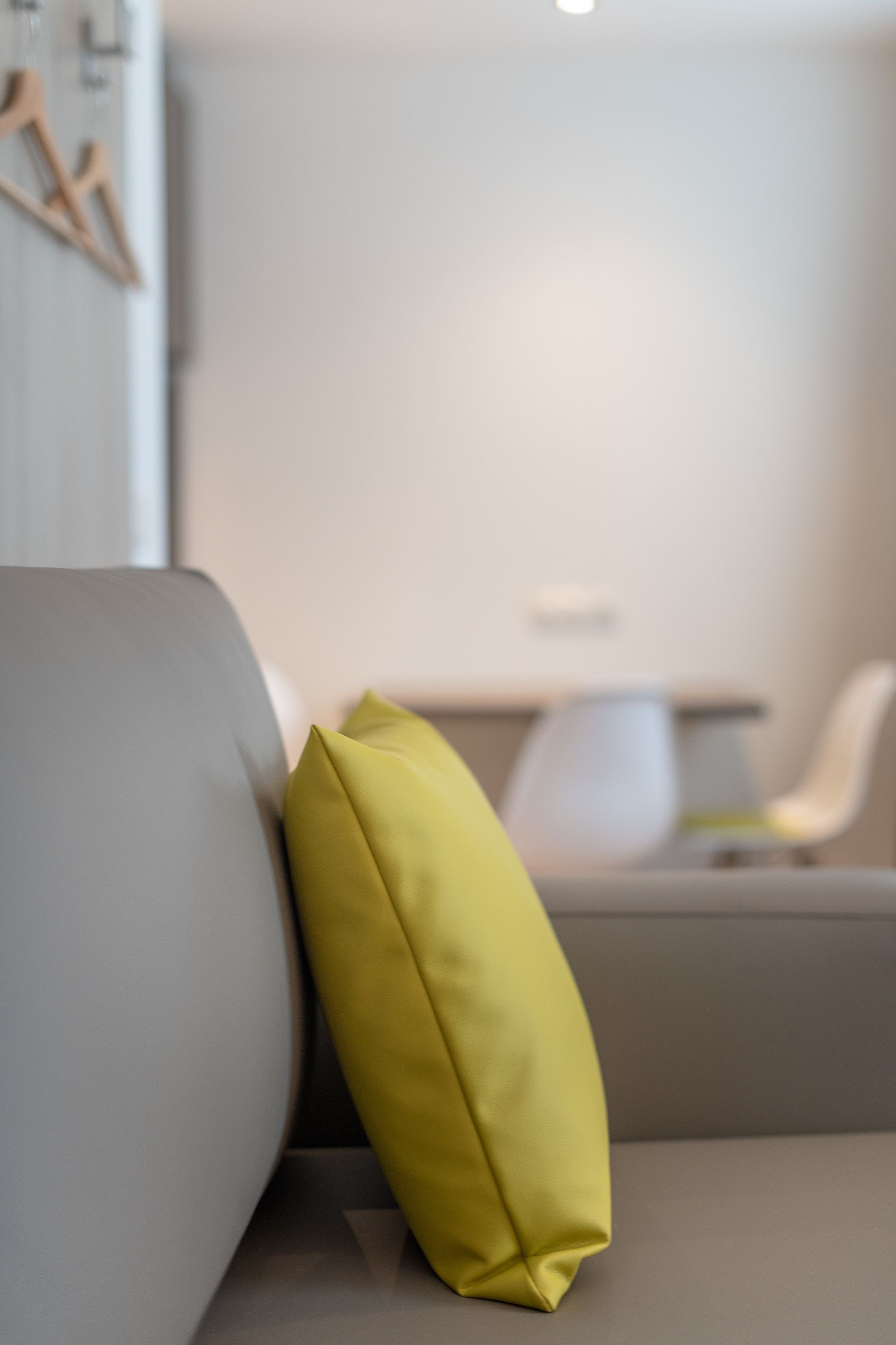 A modern living room with a sofa and a yellow pillow.