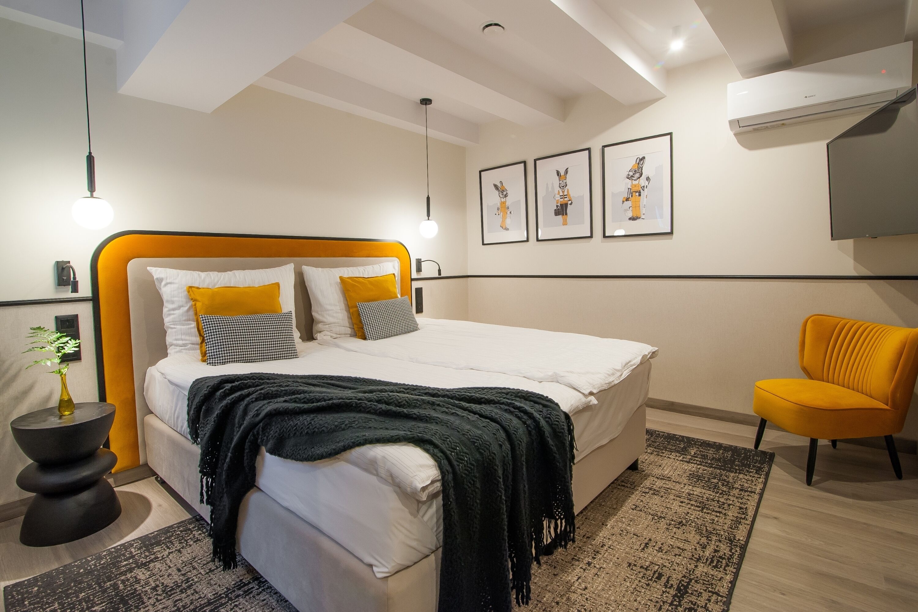 A modern bedroom with a bed, bedside tables, a chair, and artwork on the wall.