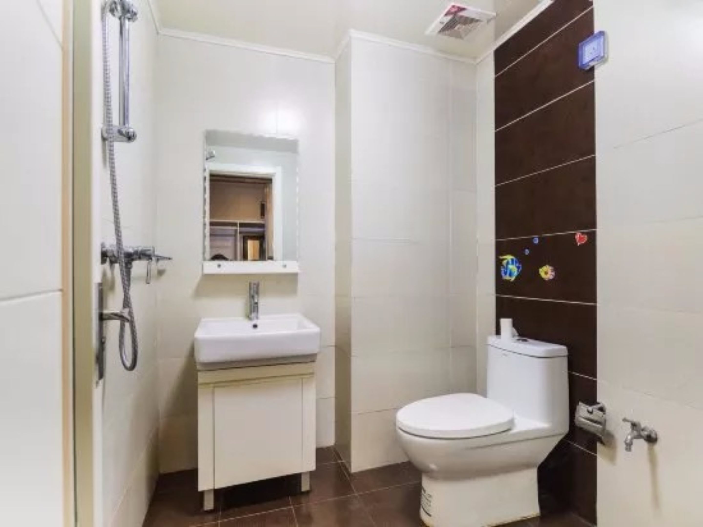 Casa de banho pequena e compacta, com lavatório branco, espelho em cima, sanita e zona de duche.