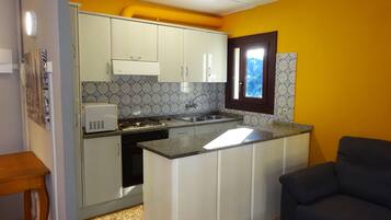 Apartamento básico, 2 habitaciones | Cocina privada | Frigorífico grande, microondas, placa de cocina y utensilios de cocina