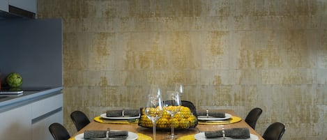 A modern dining area with a wooden table set for four, black chairs, and a black pendant light.
