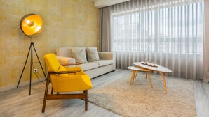 A modern living room with a sofa, yellow armchair, floor lamp, and a table with candles. - Innapartments - Passos Manuel (Porto)