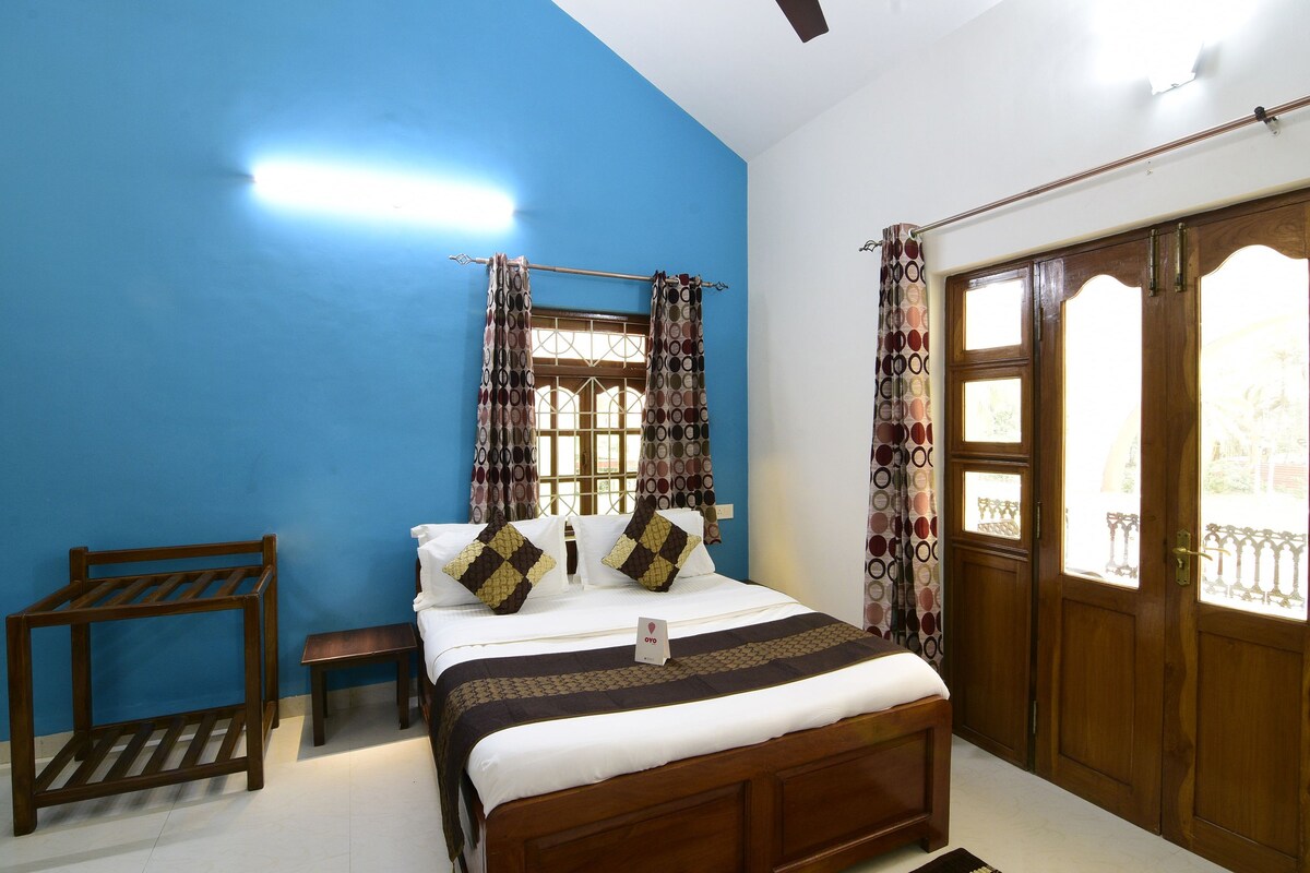 A bedroom with a bed, a wooden bench, a bedside table, and a wardrobe.
