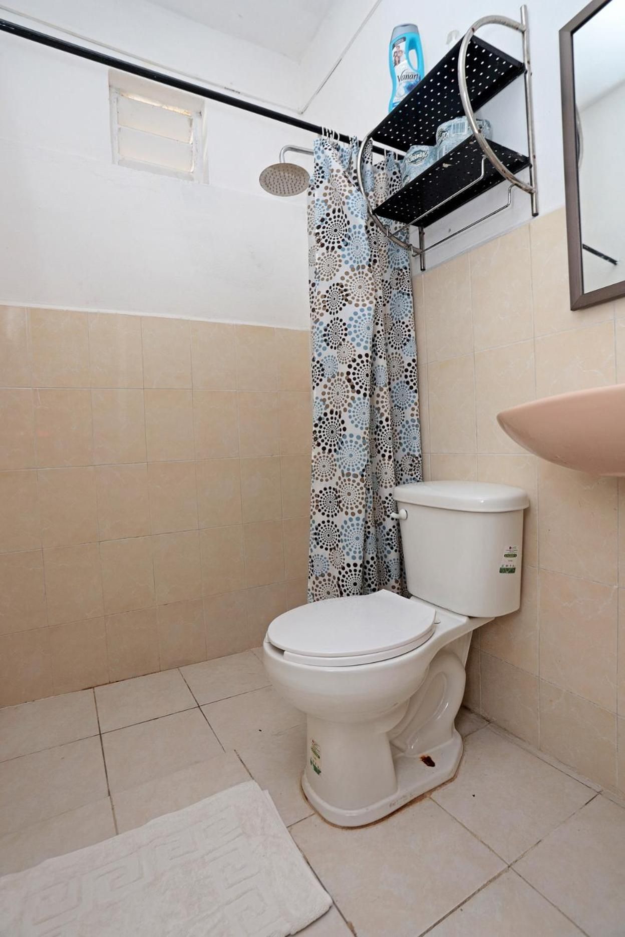 A bathroom with a toilet, a shower, and a sink.