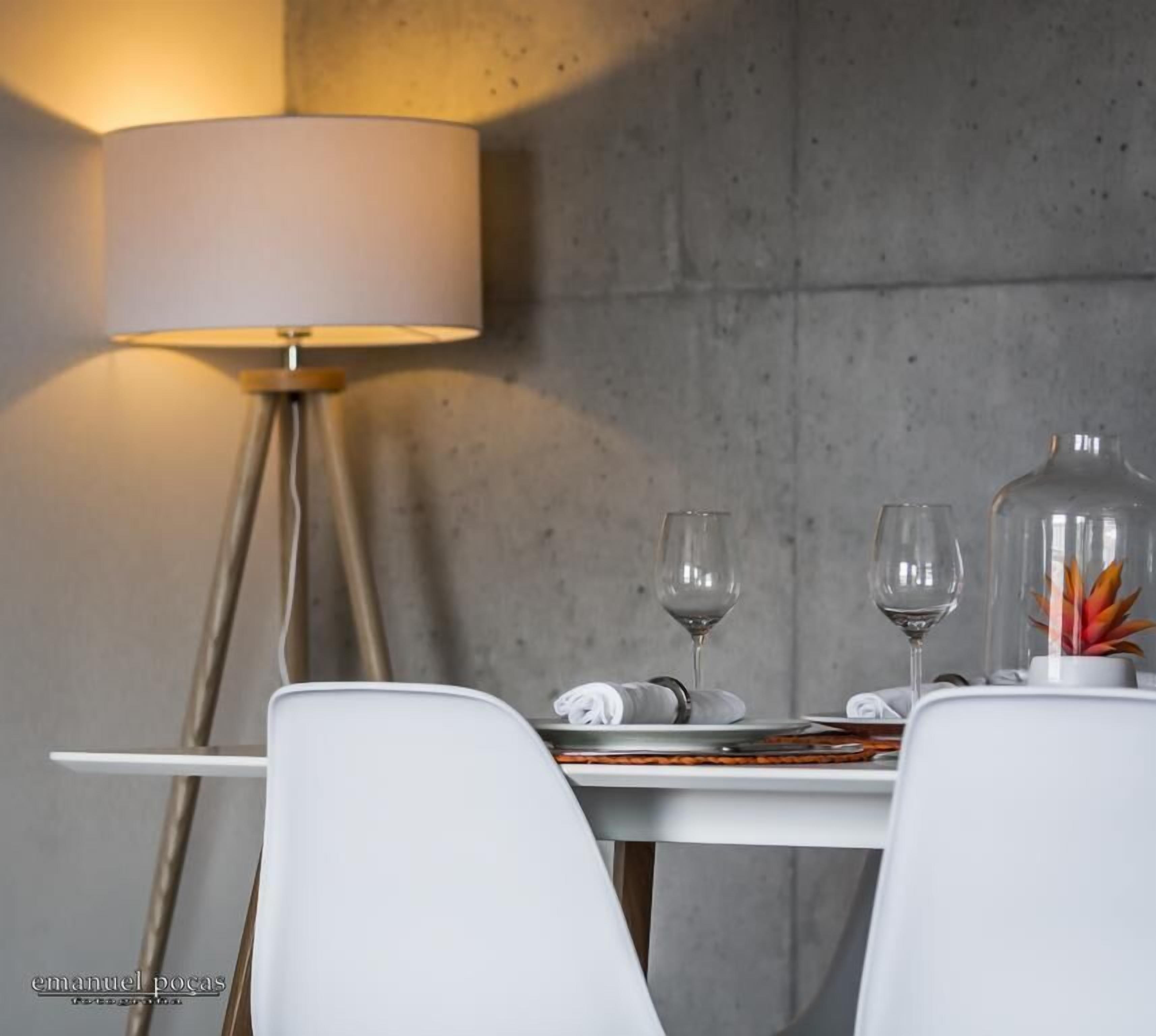 Een eethoek met een tafel voor twee, een lamp en een decoratieve plant.
