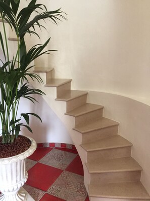 A staircase with beige steps and a potted plant on the left. - Le Colombier de la Graverie (Senots)