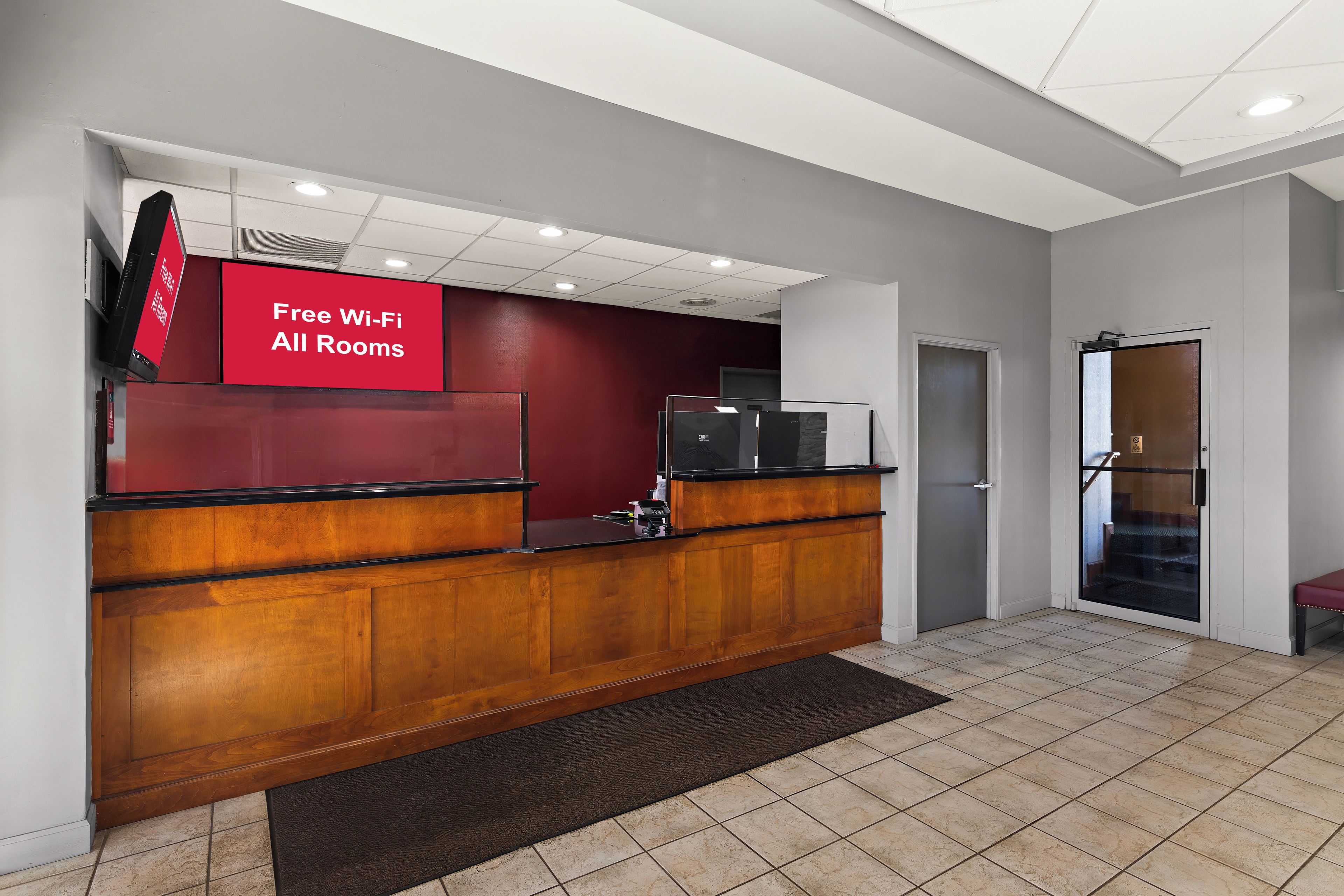 A reception desk with a red sign indicating free Wi-Fi in all rooms.