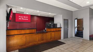 A reception desk with a red sign indicating free Wi-Fi in all rooms.