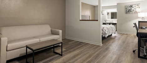 A modern living room with a sofa, a coffee table, and hardwood flooring.