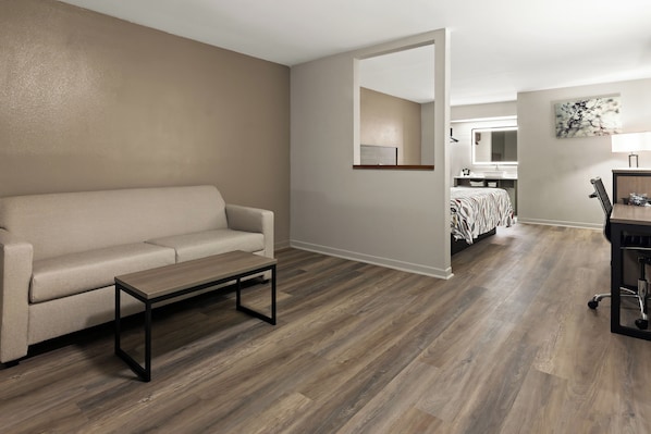 Una sala de estar moderna con sofá, mesa de centro y piso de madera.
