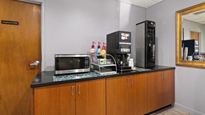 A kitchenette with a microwave, coffee machine, and a refrigerator. - Red Roof Inn & Suites Monroe, NC (Monroe)