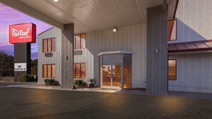 A Red Roof Inn & Suites with a modern design, featuring a prominent Red Roof sign, large windows, and a welcoming entrance. - Red Roof Inn & Suites Monroe, NC (Monroe)