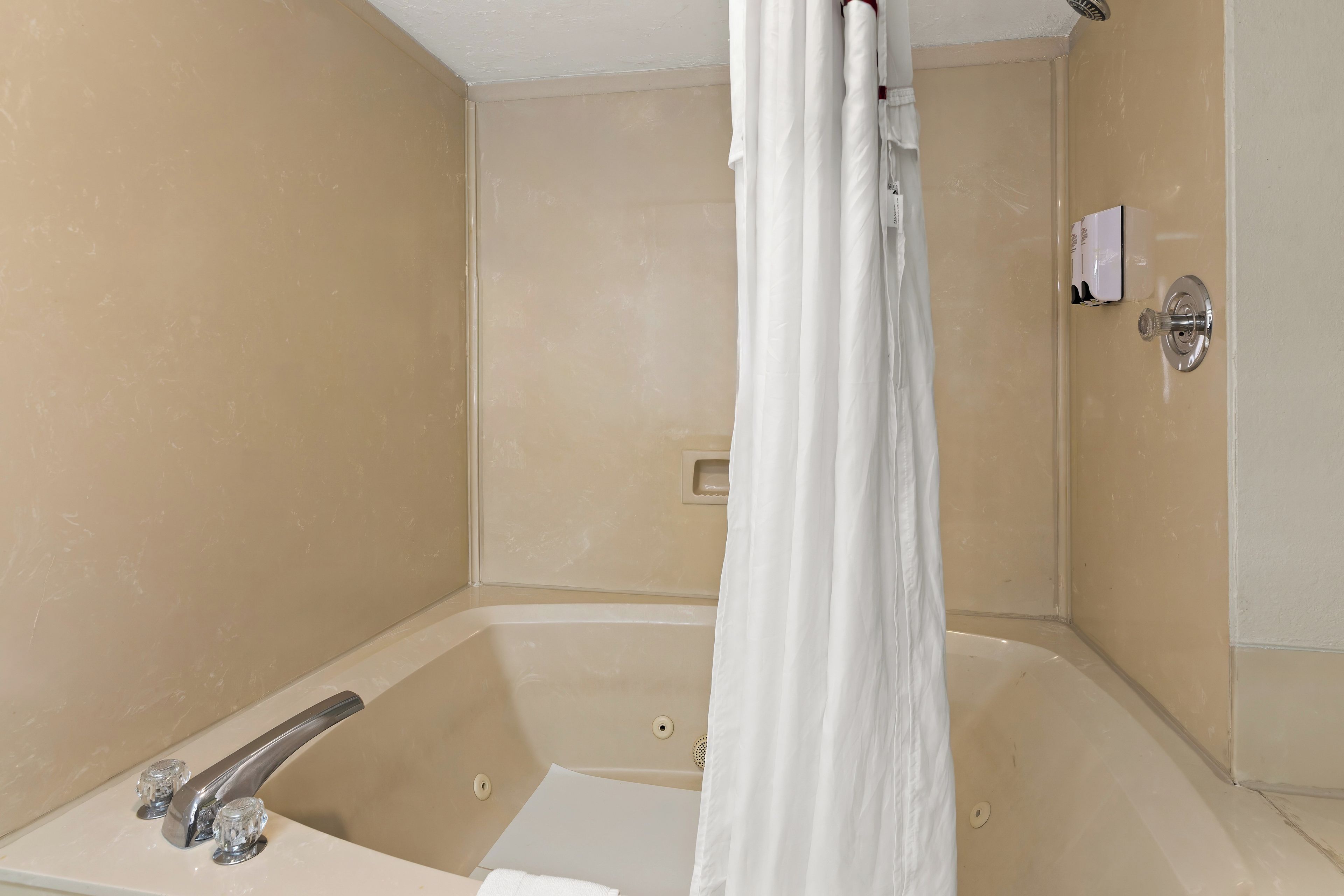 Un baño con bañera, cortina de ducha y un perchero.